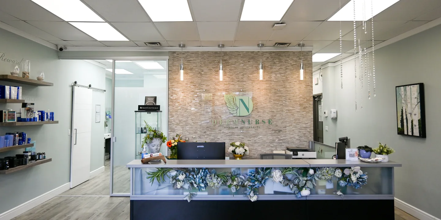 The DermNurse reception: the front desk and the logo wall, seen from the entrance
