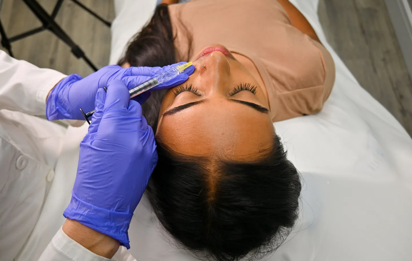 An injector treating a small spot beside the nose, seen from above