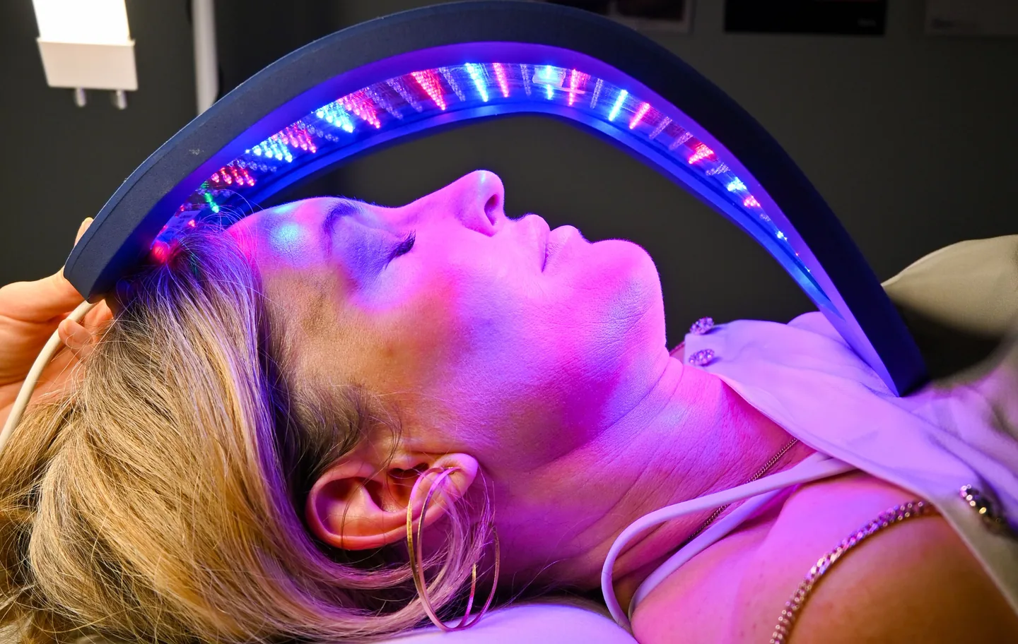 A client resting under the Celluma red light panel