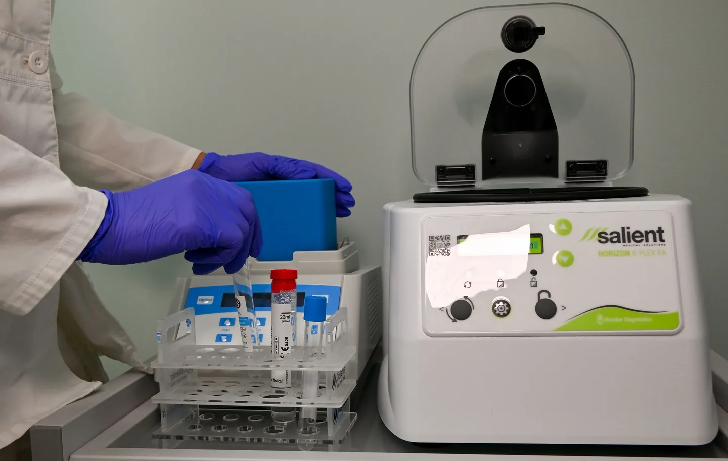 Gloved hands loading tubes into the PRP centrifuge